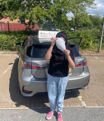 Afsha holding her practical driving test pass certificate in Shipley